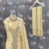 Premium mustard organza embroidered suit set with floral printed dupatta and shantoon bottom displayed in luxury studio setup