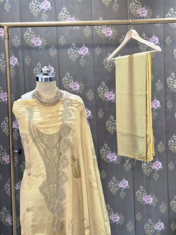 Premium mustard organza embroidered suit set with floral printed dupatta and shantoon bottom displayed in luxury studio setup