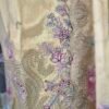 Premium mustard organza embroidered suit set with floral printed dupatta and shantoon bottom displayed in luxury studio setup