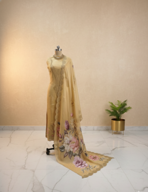 Premium mustard organza embroidered suit set with floral printed dupatta and shantoon bottom displayed in luxury studio setup Premium mustard organza embroidered suit set with floral printed dupatta and shantoon bottom displayed in luxury studio setup